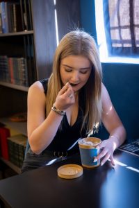 A happy woman enjoys a cannabis-infused ice cream in Seknd Nature's Linksfield member's lounge, situated in Johannesburg